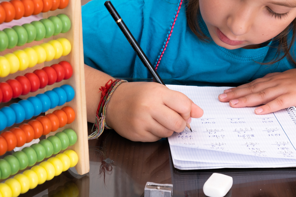 Little Girl Doing Math Homework with an Abacus